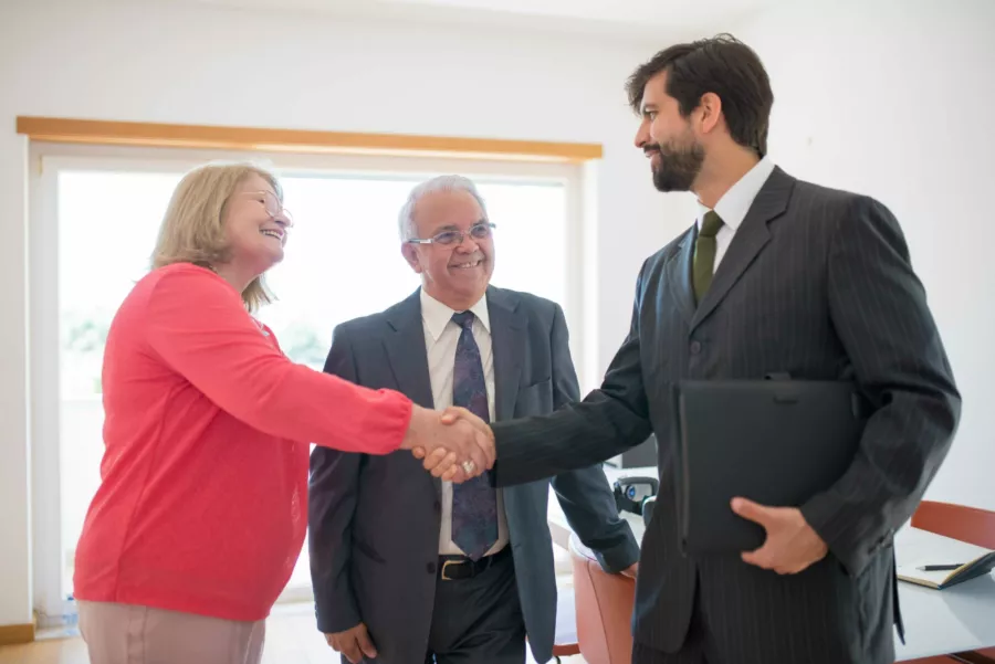 Professional man shaking hand of elderly woman