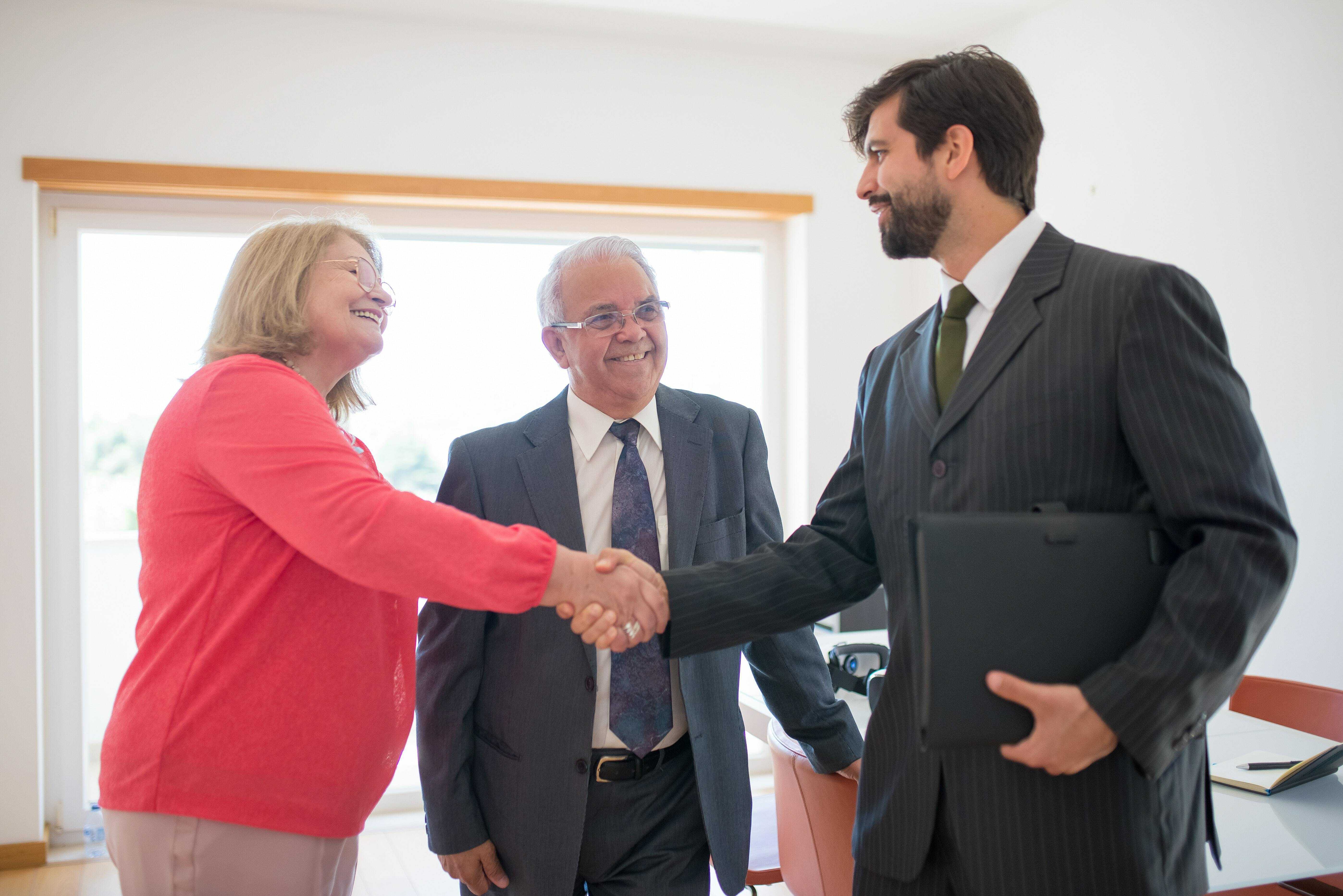 Professional man shaking hand of elderly woman